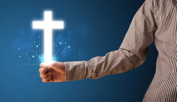 Glowing cross in the hand of a businessman — Stock Photo, Image