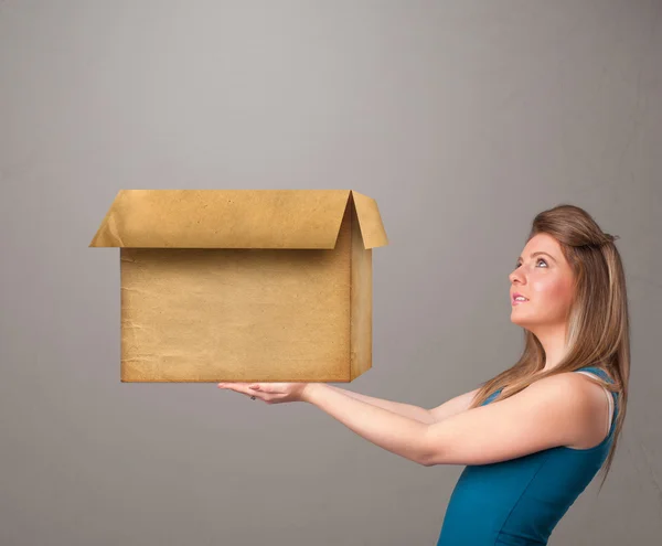 Jovem segurando uma caixa de papelão vazia — Fotografia de Stock