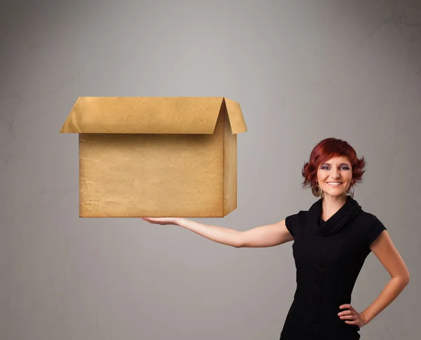 Mujer joven sosteniendo una caja de cartón vacía — Foto de Stock