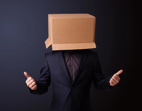 Young man gesturing with a cardboard box on his head — Stock Photo, Image