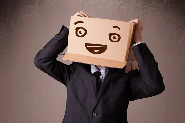 Smil と彼の頭の上の段ボール箱でジェスチャーの実業家 — ストック写真