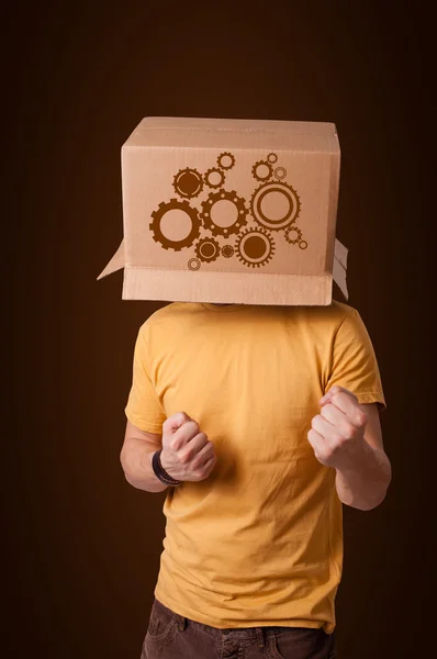 Young man gesturing with a cardboard box on his head with spur w — Stock Photo, Image