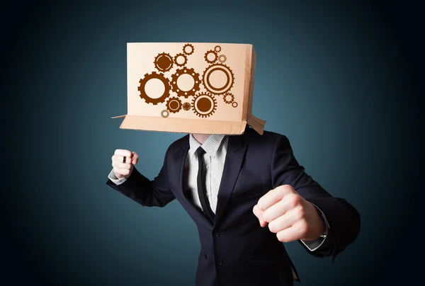 Businessman gesturing with a cardboard box on his head with spur — Stock Photo, Image