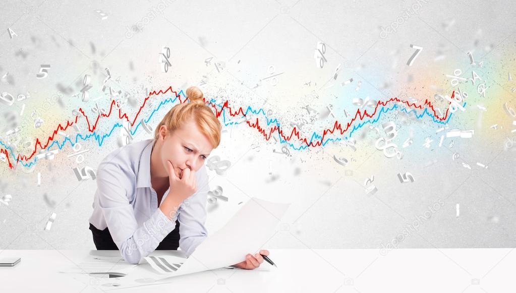 Business woman sitting at table with stock market graph 