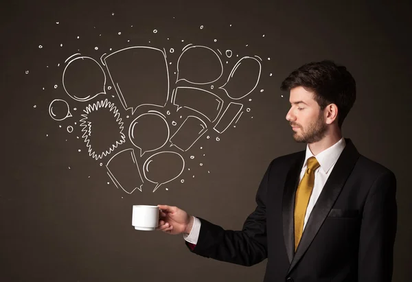 Businessman holding a white cup with speech bubbles — Stock Photo, Image