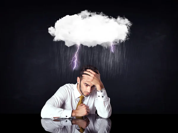 Depressed businessman sitting under a cloud — Stock Photo, Image