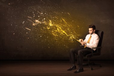 Arka planda tablet ve enerji patlaması olan iş adamı