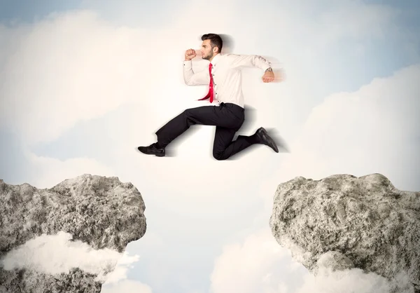 Hombre de negocios feliz saltando por un acantilado — Foto de Stock