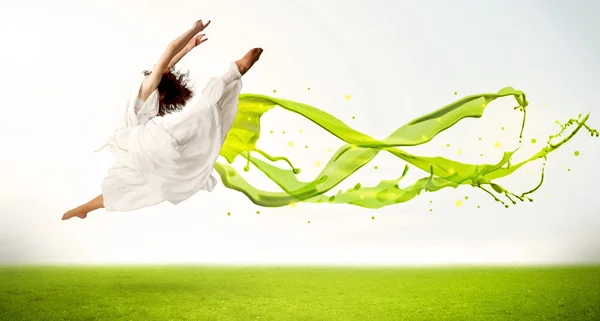 Pretty girl jumping with green abstract liquid dress — Stock Photo, Image