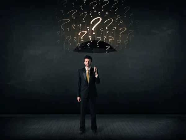 Businessman with umbrella and a lot of drawn question marks — Stock Photo, Image