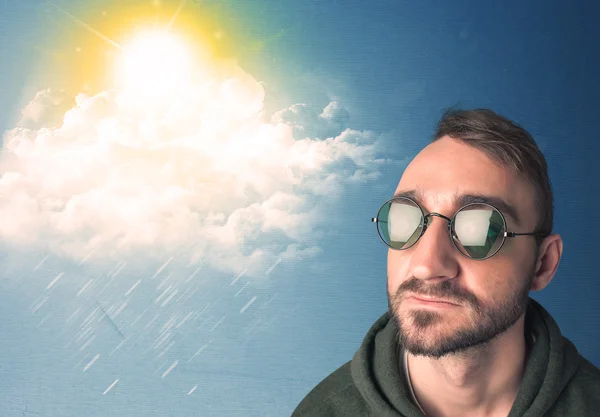 Young person looking with sunglasses at clouds and sun — Stock Photo, Image