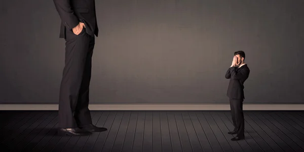 Pequeño hombre de negocios frente a un concepto de piernas de jefe gigante —  Fotos de Stock