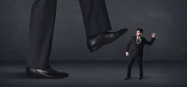 Giant person stepping on a little businessman concept — Stock Photo, Image