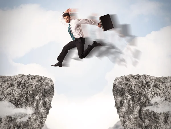 Funny business man jumping over rocks with gap — Stock Photo, Image