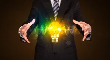 Elinde ampul tutan bir iş adamı.