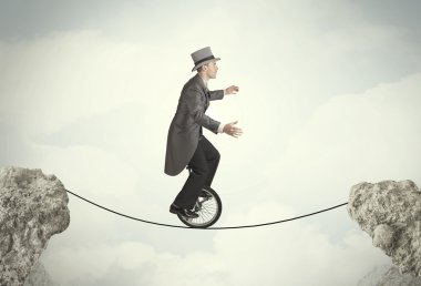Uçurumlar arasında tekli bisiklet süren cesur bir iş adamı.