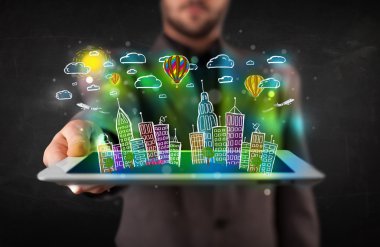 Elle çizilmiş şehir manzaralı tablet gösteren genç kişi