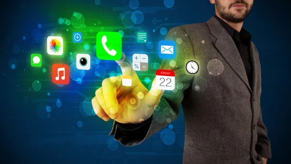 Hombre de negocios guapo presionando iconos coloridos aplicación móvil con bok — Foto de Stock