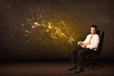 Arka planda tablet ve enerji patlaması olan iş adamı