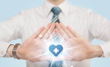 Eller mavi haçlı bir kalp yaratıyor.