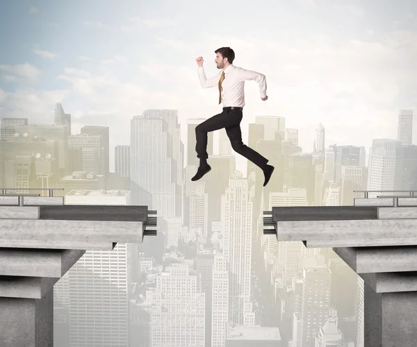 Homem de negócios energético saltando sobre uma ponte com lacuna — Fotografia de Stock