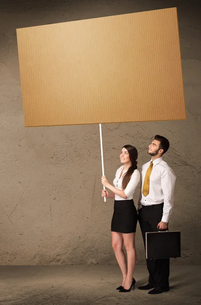 Business couple with blank cardboard — Stock Photo, Image