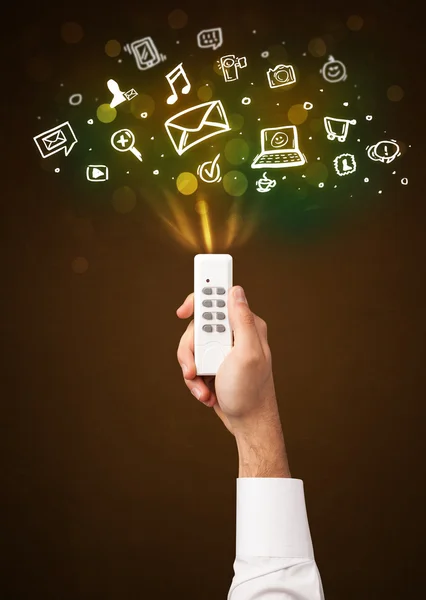 Hand with remote control and social media icons — Stock Photo, Image