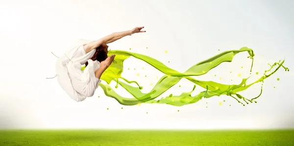 Pretty girl jumping with green abstract liquid dress — Stock Photo, Image