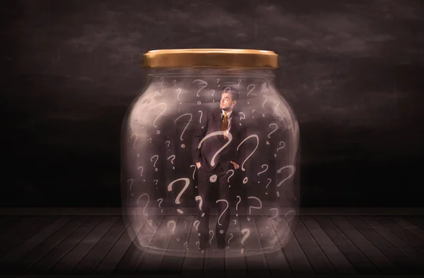 Businessman locked into a jar with question marks concept — Stock Photo, Image
