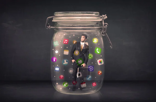Empresario capturado en un frasco de vidrio con iconos de aplicaciones de colores con —  Fotos de Stock