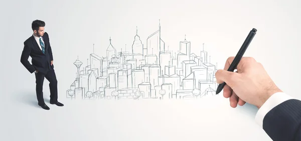 Businessman looking at hand drawn city on wall — Stock Photo, Image
