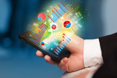 İşadamı elinde grafik sembollü akıllı telefon tutuyor.