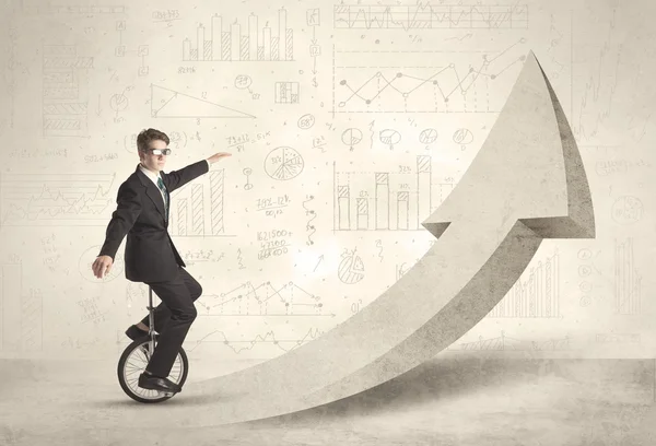 Happy business man riding a monocycle up on an arrow — Stock Photo, Image