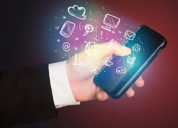 Hand holding smartphone with media icons — Stock Photo, Image