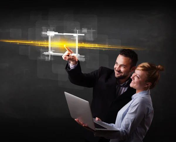 Young tech business couple touching button with orange light bea — Stock Photo, Image