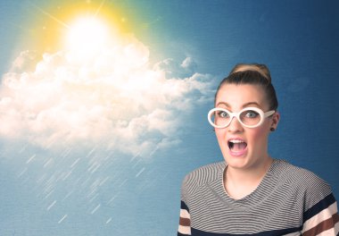 Güneş gözlükleriyle bulutlara ve güneşe bakan genç adam