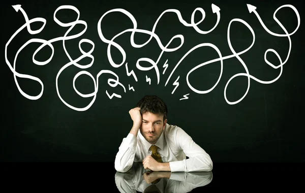 Depressed businessman sitting under drawn direction lines — Stock Photo, Image