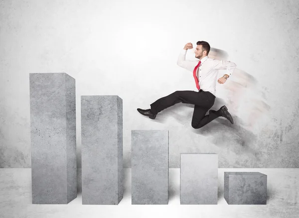 Successful business man jumping over charts on background — Stock Photo, Image