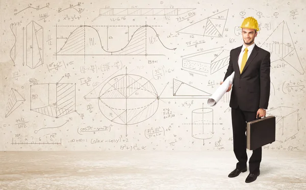 Handsome engineer calculating with hand drawn background — Stock Photo, Image