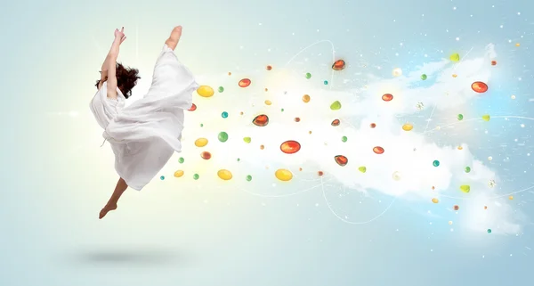 Женщина прыгает с разноцветными гемами и кристаллами на батуте — стоковое фото