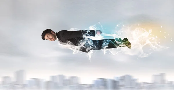 Bohater superman latający nad miastem z pozostawionym dymem — Zdjęcie stockowe