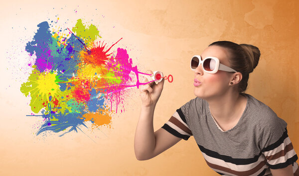 Cute girl blowing colorful splash graffiti 