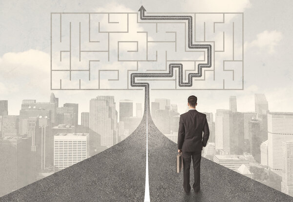 Бизнесмен смотрит на дорогу с лабиринтом и решением