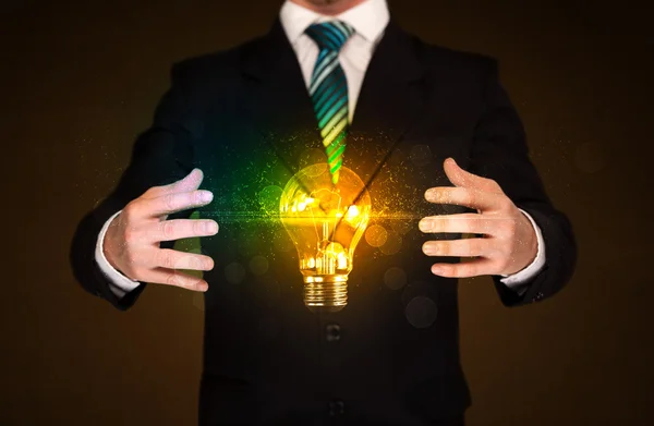 Businessman holding light bulb — Stock Photo, Image