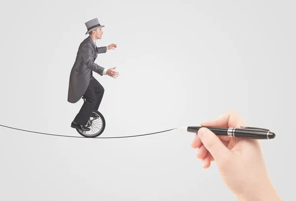 Businessman riding monocycle on a rope drawn by hand — Stock Photo, Image