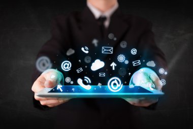 Mavi teknoloji simgeleri ve sembolleri olan bir tablet tutan kişi