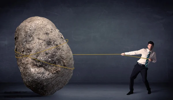 Empresário puxando rocha enorme com uma corda — Fotografia de Stock