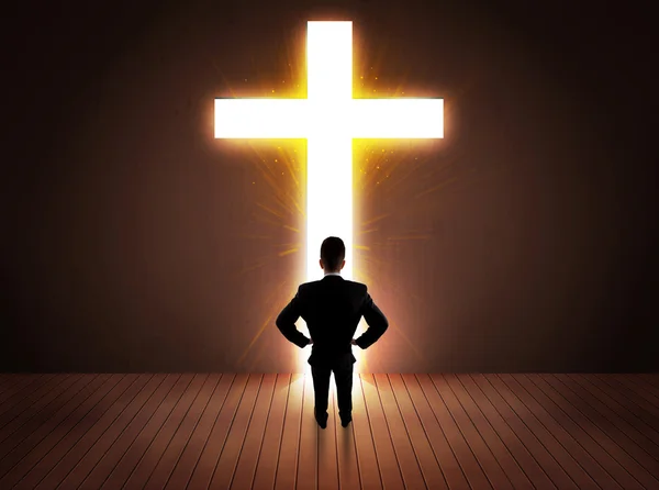 Чоловік дивиться на яскравий знак хреста — стокове фото