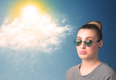 Güneş gözlükleriyle bulutlara ve güneşe bakan genç adam