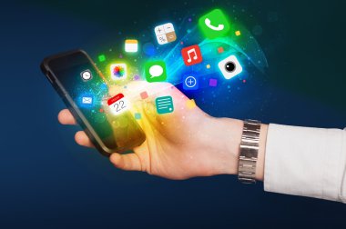 Renkli uygulama simgeleriyle el ele tutuşan akıllı telefon